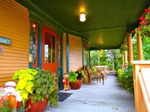 a porch of a house with potted plants on it at The Scofield House B&B in Sturgeon Bay