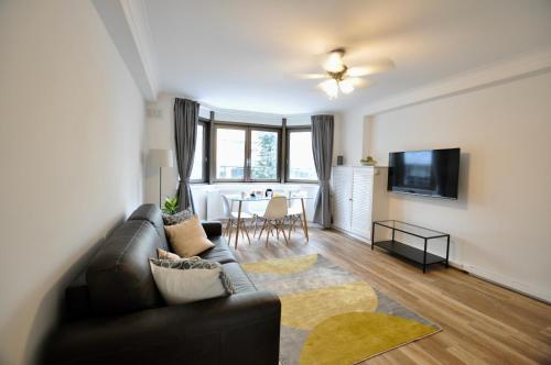 uma sala de estar com um sofá e uma mesa em Marlyn Lodge – City of London em Londres