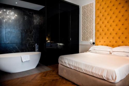 een slaapkamer met een groot bed en een bad bij Boutique Centrale Palace Hotel in Rome