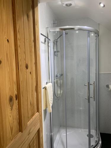 a bathroom with a shower with a glass shower stall at Launceston Villa in Whitby