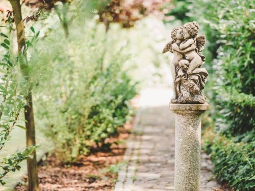 una statua di un bambino su una colonna di pietra in un giardino di Seeschloß a Lanke