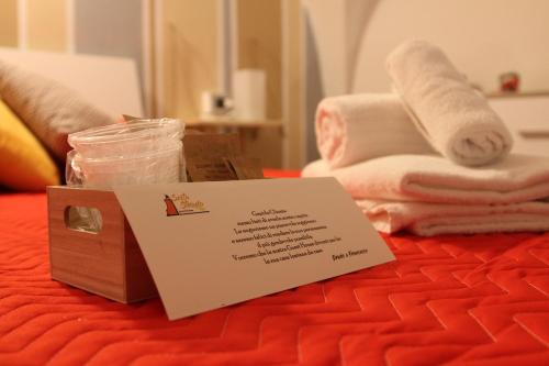 ein Schild auf einem Bett mit Handtüchern in der Unterkunft Sesta Strada in Civitavecchia