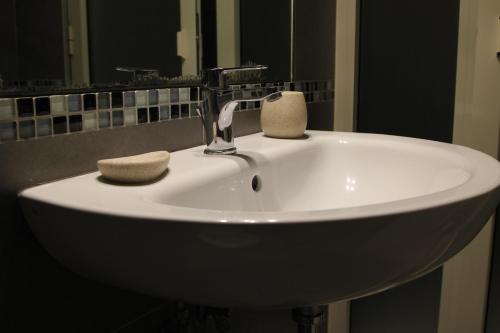 ein weißes Waschbecken mit einem Wasserhahn im Bad in der Unterkunft Sesta Strada in Civitavecchia