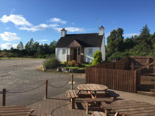 una casa con una mesa de picnic y una valla en The Shandwick Inn, en Tain