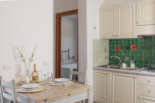 a kitchen with a table with plates and wine glasses at Palau Green Village in Palau