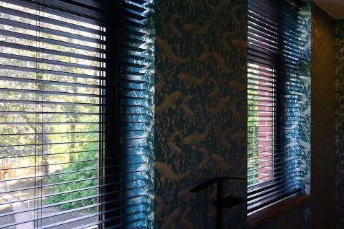two windows in a room with blinds on them at Fiertelmeers Boutique B&B in Ronse