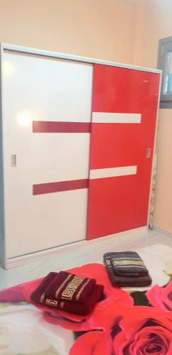 a red and white door with two cell phones on the floor at Perfect Suites in Neos Marmaras