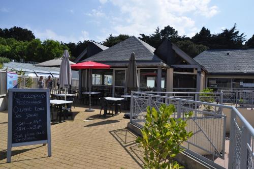 a restaurant with tables and umbrellas and a sign at Mobilhome Victory 56 in Quiberon