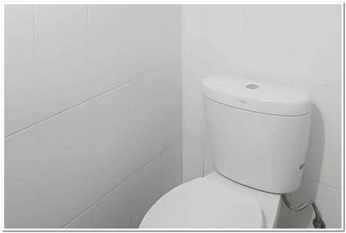 een badkamer met een wit toilet in een kamer bij RedDoorz Apartment at Grand Sentraland Karawang in Telukjambe