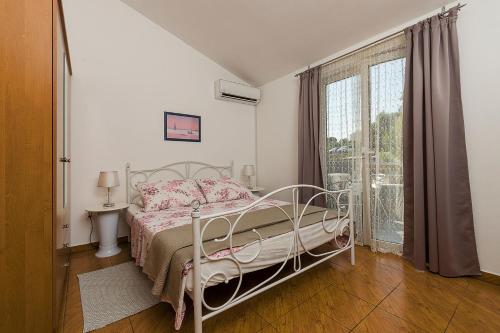 a bedroom with a bed and a large window at Apartman, studio and room Kata in Pula