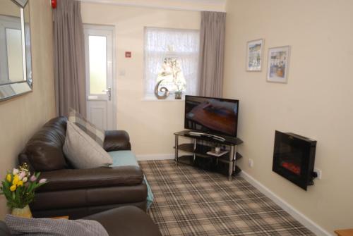 ein Wohnzimmer mit einem Sofa und einem TV in der Unterkunft Saltburn Holidays 3 Park View in Loftus