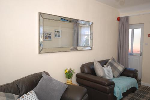 ein Wohnzimmer mit einem Sofa und einem Spiegel in der Unterkunft Saltburn Holidays 3 Park View in Loftus