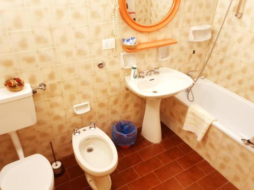 uma casa de banho com um WC, um lavatório e uma banheira em Albergo Trieste em Lorenzago