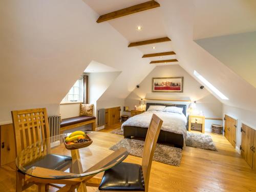 a bedroom with a bed and a table and chairs at Souters Cottage Annexe in Chichester