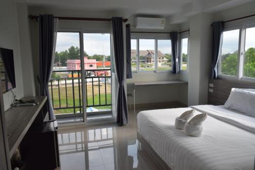 a bedroom with a bed and a large window at The grace kok udom in Prachin Buri