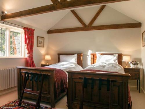 a bedroom with two beds and two tables in it at Oak House Farm in Edenbridge