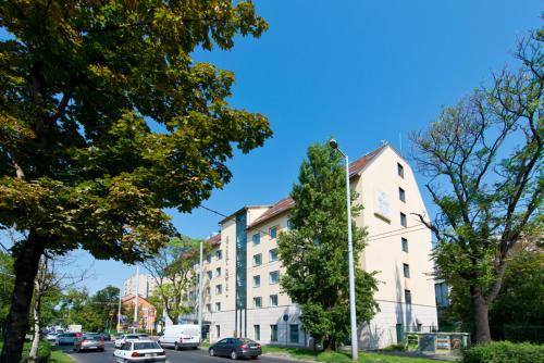 un bâtiment dans une rue avec des voitures garées dans la rue dans l'établissement ACHAT Hotel Budapest, à Budapest