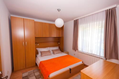 a small bedroom with a bed and a window at Apartmani Strsoglavec in Krapinske Toplice