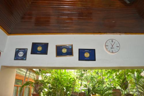 a clock and pictures on the wall of a building at Familyhouse in Negombo