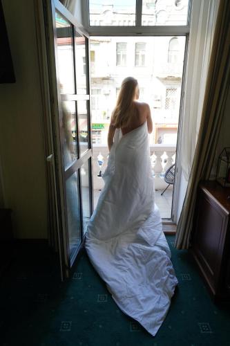 a woman in a wedding dress looking out of a window at Number 21 by DBI in Kyiv