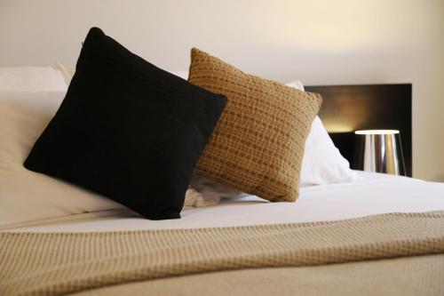a bed with black and white pillows on it at Stanislas Maison d'hotes in Abidjan