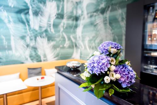 Boutique Centrale Palace Hotel في روما: باقة من الزهور الأرجوانية جالسة على منضدة