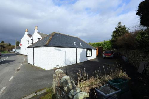 a small white building next to a street at Star Hotel in Kirkcudbright