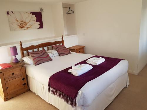 a bedroom with a bed with towels on it at Black Isle Holiday Apartments in Avoch