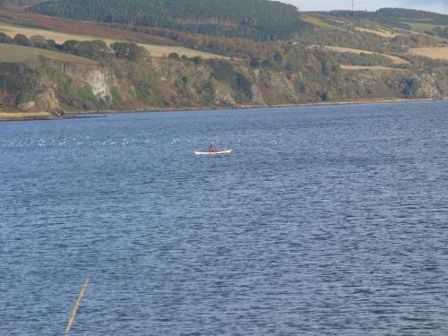 a person in a boat in a large body of water at Black Isle Holiday Apartments in Avoch