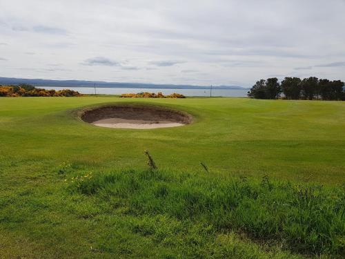 a hole in the middle of a golf green at Black Isle Holiday Apartments in Avoch