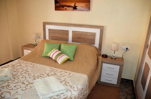 a bedroom with a bed with two night stands and two lamps at Naufragos Beach Apartment in Torrevieja