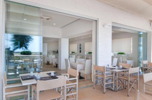 Un comedor con mesas y sillas y un restaurante. en Hotel Levante, en Caorle
