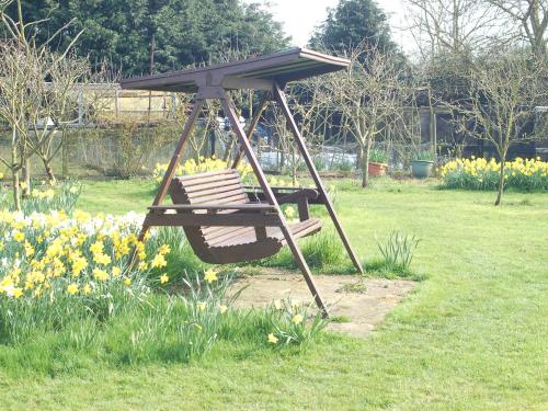 einen Schaukelstuhl in einem Garten mit Blumen in der Unterkunft Strenneth in Fersfield