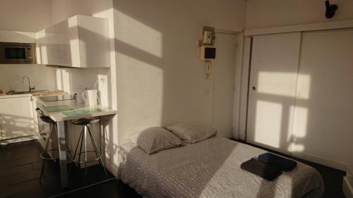Il comprend une petite chambre avec un lit et une petite cuisine. dans l'établissement Studio Hypercentre proche gares et métro, à Lille