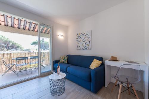 un salon avec un canapé bleu et un balcon dans l'établissement Studio Del Mar, à Saint-Cyr-sur-Mer