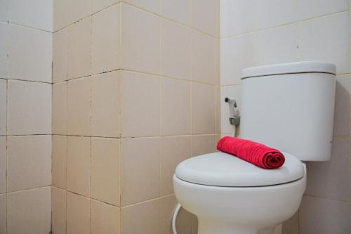 a red towel sitting on top of a toilet in a bathroom at Chic Studio at Serpong Green View Apartment By Travelio in Ciater-hilir