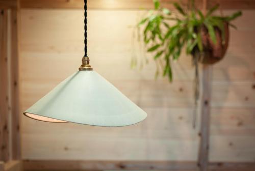 a white pendant light hanging from a ceiling at FOLK FOLK Hostel, Cafe & Bar in Ise