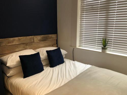 a bedroom with a bed with two pillows and a window at Sapphire House Sasco Apartments in Blackpool
