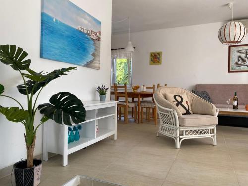 a living room with a chair and a dining room at Apartment Lavanda in Molat