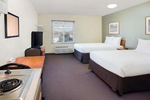 a hotel room with two beds and a stove at WoodSpring Suites Baton Rouge Airline Highway in Baton Rouge