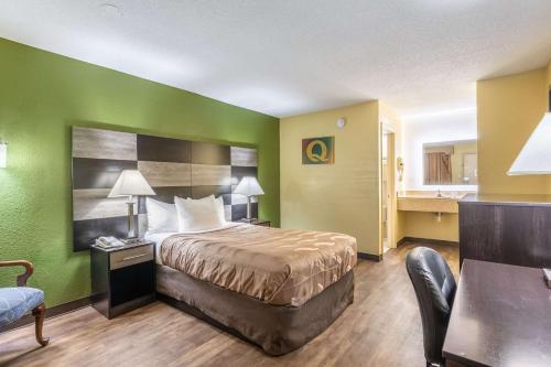 a hotel room with a bed and a chair at Quality Inn in Kings Mountain