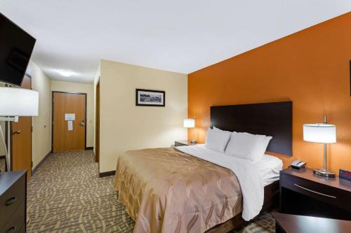 a hotel room with a bed and a flat screen tv at Quality Inn Wooster in Wooster