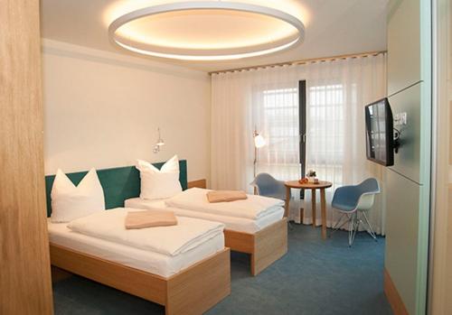 ein Hotelzimmer mit 2 Betten und einem TV in der Unterkunft TraumHaus im Elsterpark in Herzberg