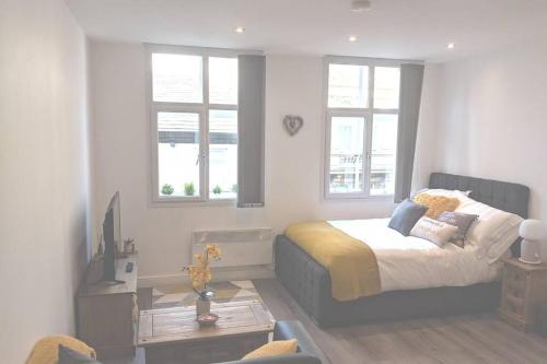 1 dormitorio con 1 cama y 2 ventanas en NEW APARTMENT - Offline Bookings on 079-504-13594 en Bradford