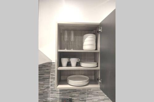 una cocina con platos y platos en un estante en NEW APARTMENT - Offline Bookings on 079-504-13594, en Bradford