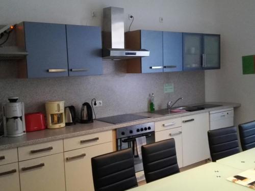 a kitchen with blue cabinets and a table and chairs at Sultania's Melanchthon in Nürnberg