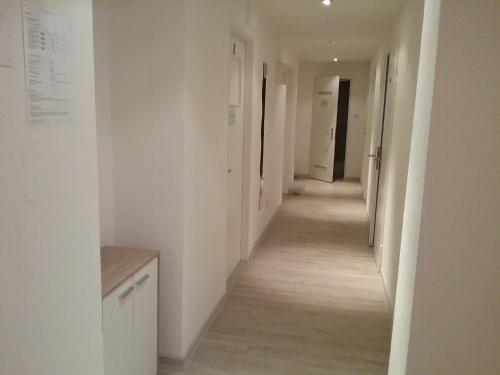 un lungo corridoio con pareti bianche e pavimenti in legno di Sultania's Melanchthon a Norimberga