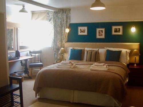 una camera da letto con un grande letto con asciugamani di St Quintin Arms a Harpham