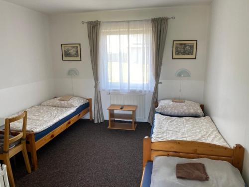 - une chambre avec 2 lits et une fenêtre dans l'établissement Penzion Kameňák, à Kamenný Újezd