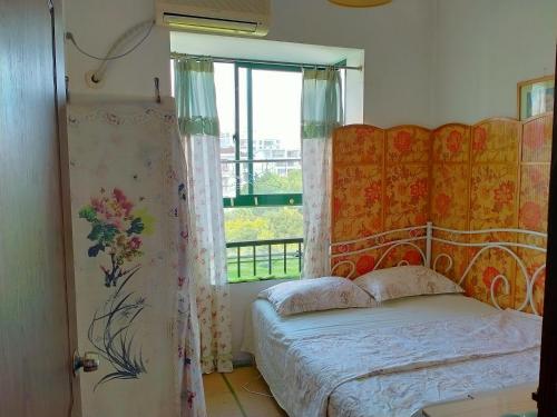 a bedroom with a bed and a window at Yi Ju Homestay-ZhuanQiao Subway Station, MinHang District in Shanghai